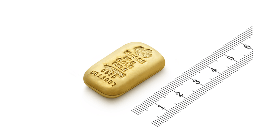 a 50 g gold cast bar from pamp laying down on white background with a ruler next to it